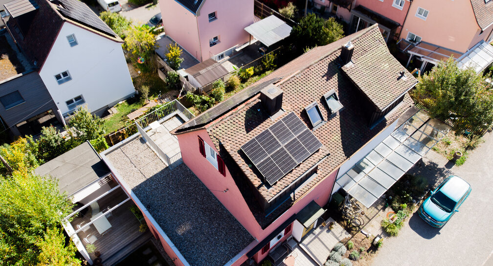 Detailreiche Luftaufnahme der Solarmodule auf dem Schrägdach eines Einfamilienhauses in Schaffhausen mit angrenzender Terrasse.
