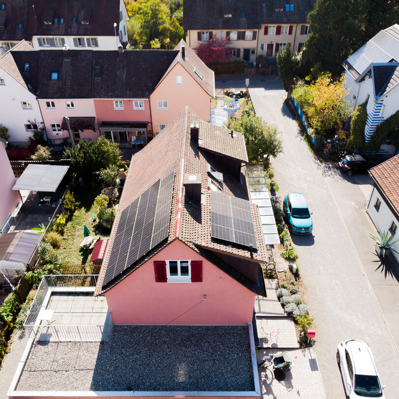 Photovoltaikanlage auf dem Ziegeldach eines Einfamilienhauses in Schaffhausen mit Solarmodulen auf zwei Dachflächen, aus der Vogelperspektive.